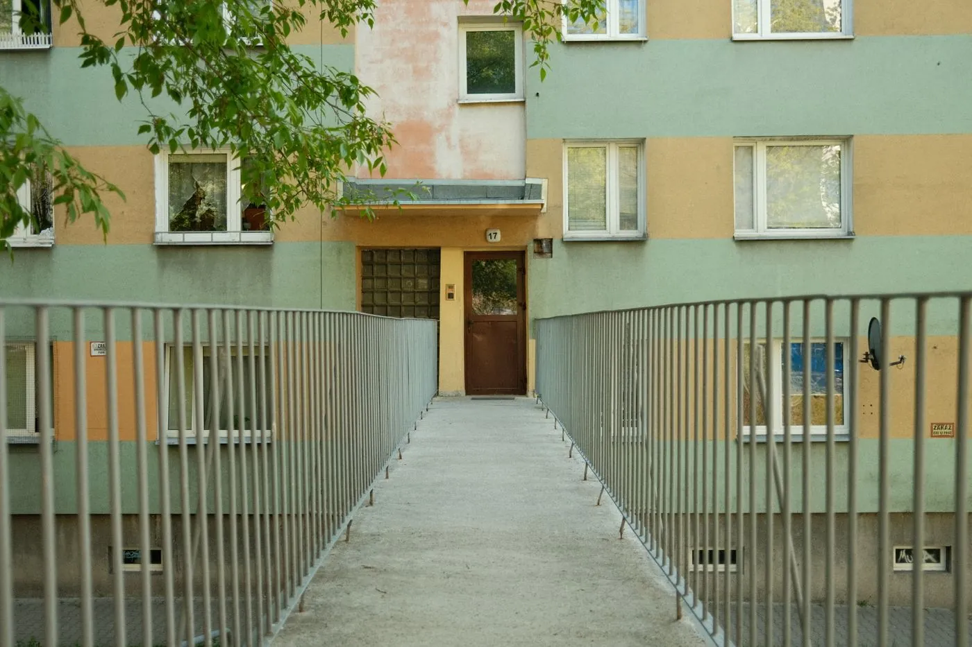 Vstup do bytového domu s lávkou a zábradlím