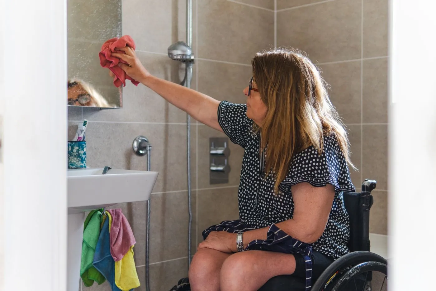 Žena na vozíku uklízí bezbariérovou koupelnu