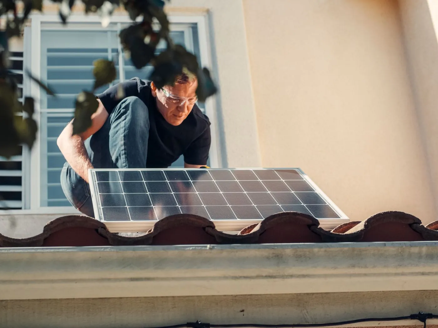 Technik instaluje fotovoltaický panel na střechu